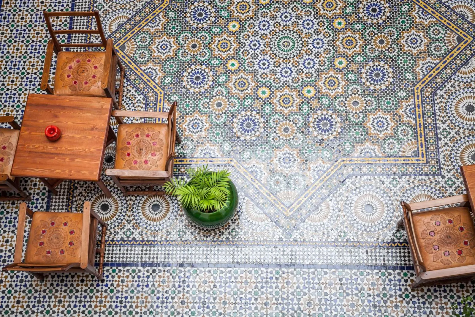 Une table du patio vue de la galerie, sur le sol de zellige