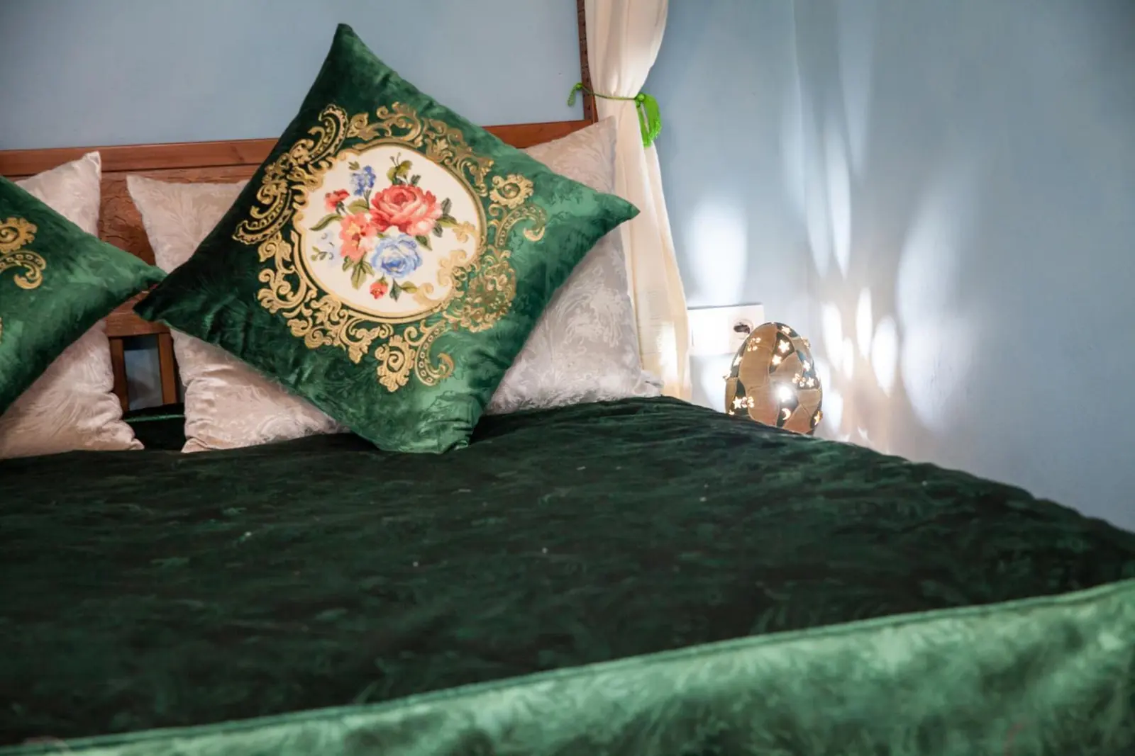 Chambre Deluxe : le lit et ses coussins brodés