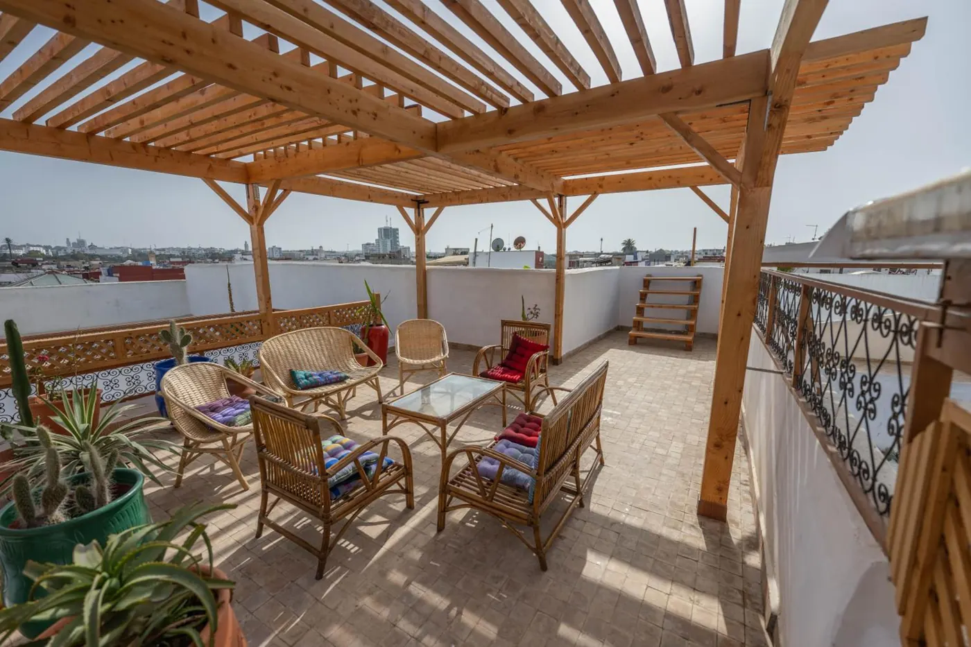 La terrasse sur le toit, sa pergola en bois et ses fauteuils